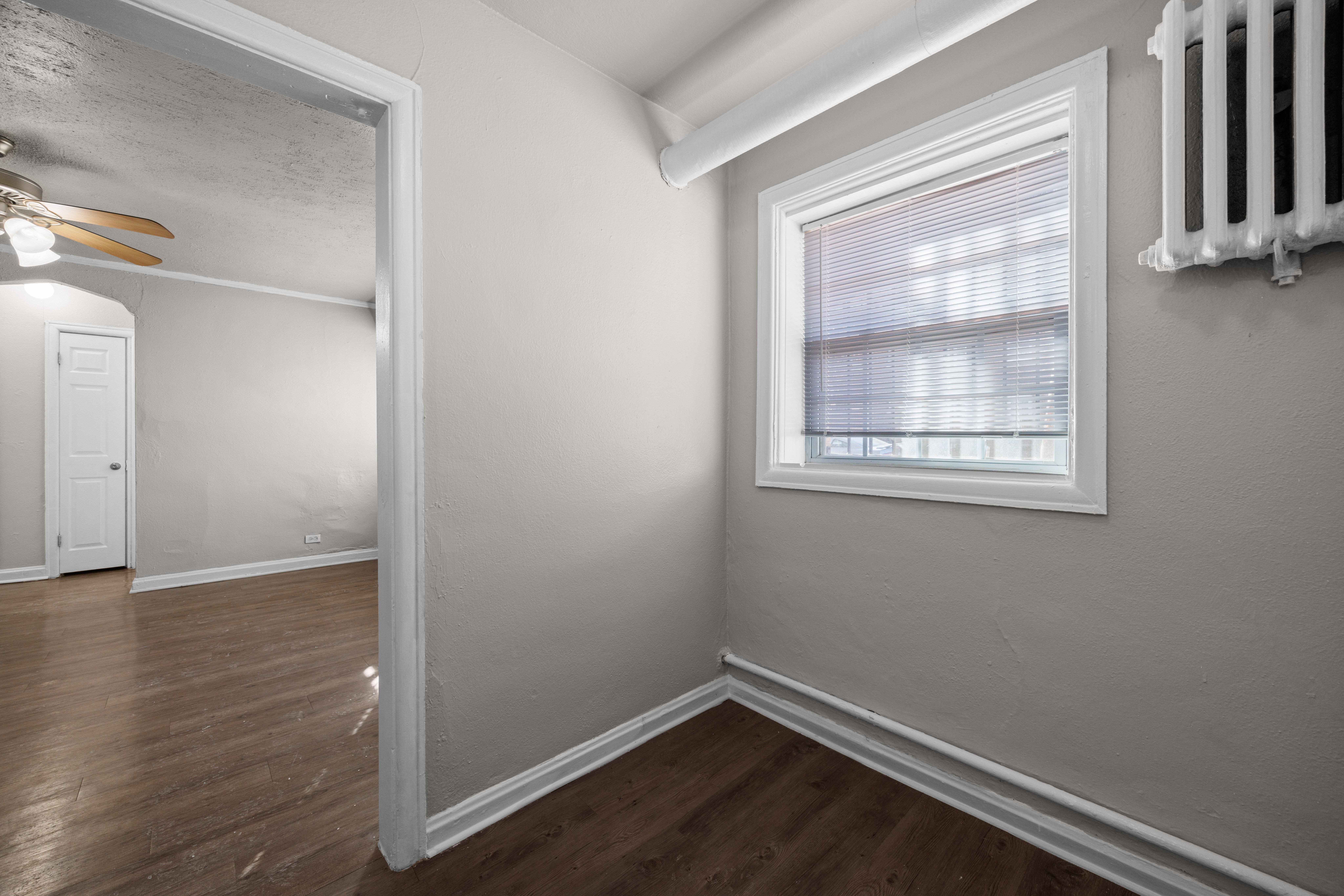 A room with a window and a ceiling fan.